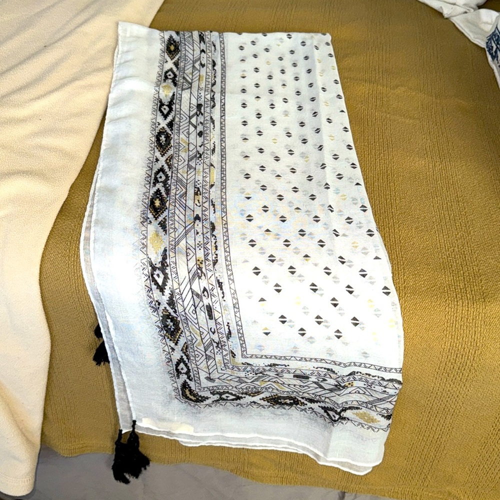 Green label black gold and whitee tasseled in black highlights in gold scarf